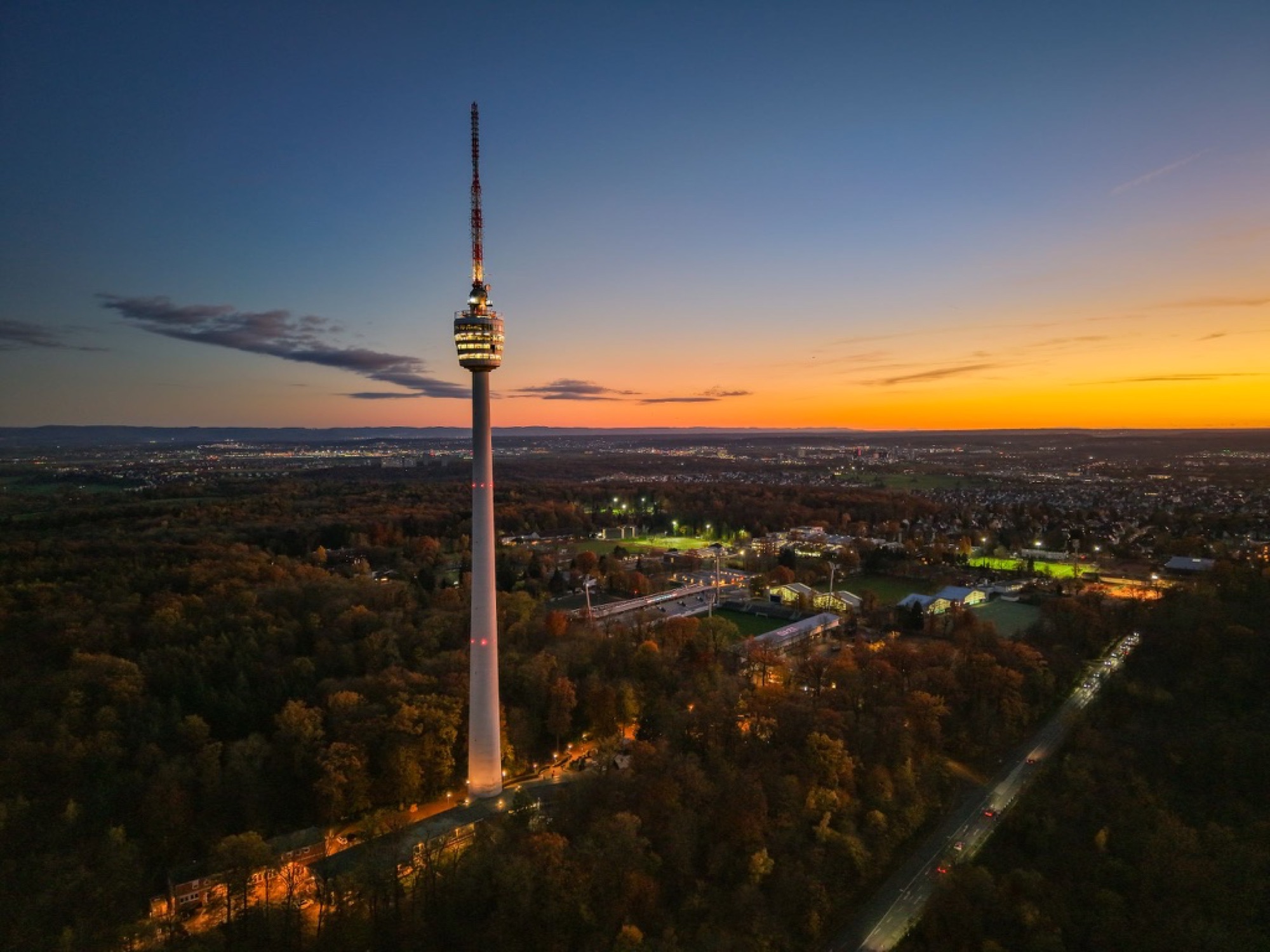 Fernsehturm bei Sonnenuntergang über einer Stadt