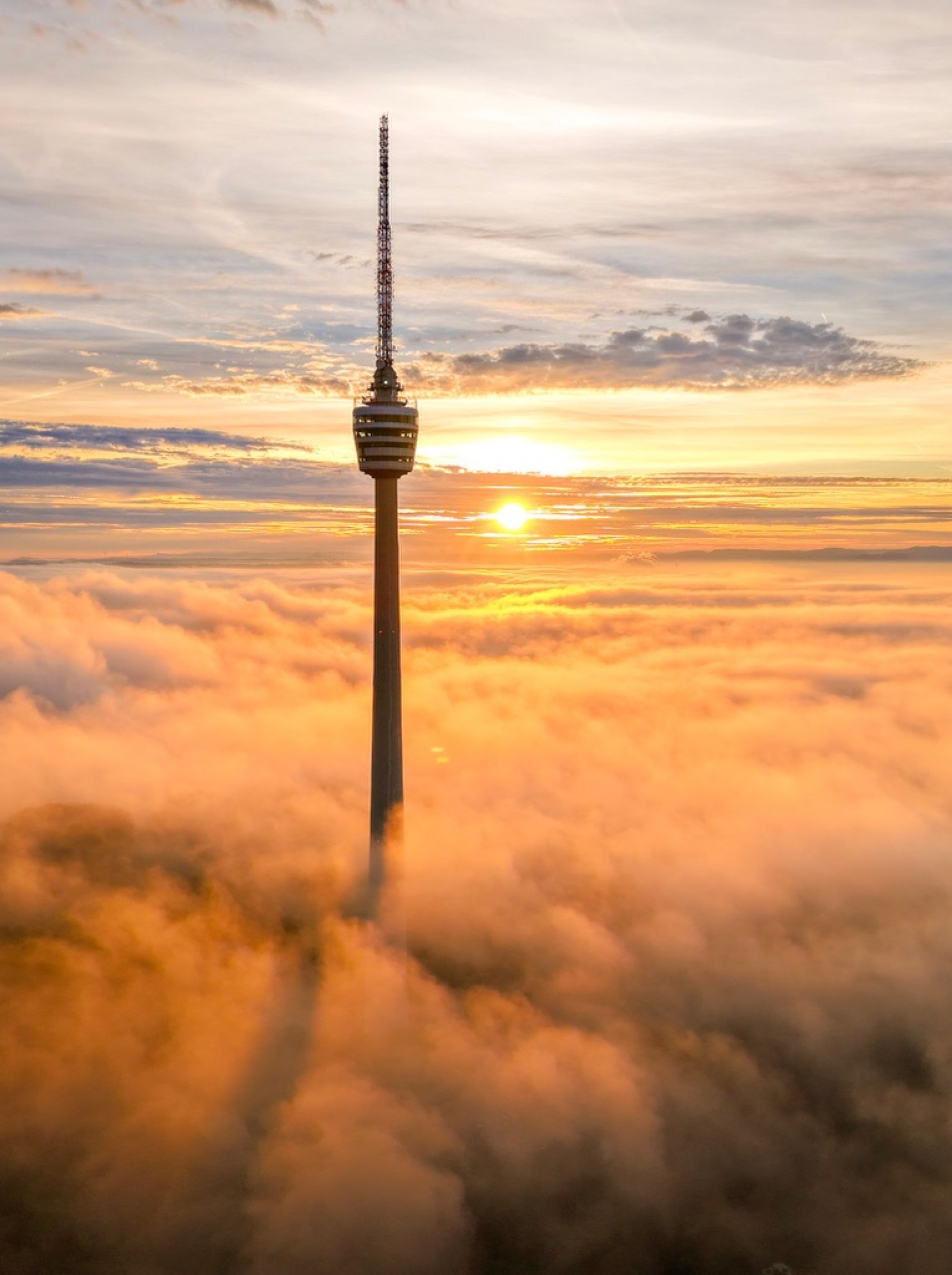 Fernsehturm über einem Wolkenmeer bei Sonnenaufgang