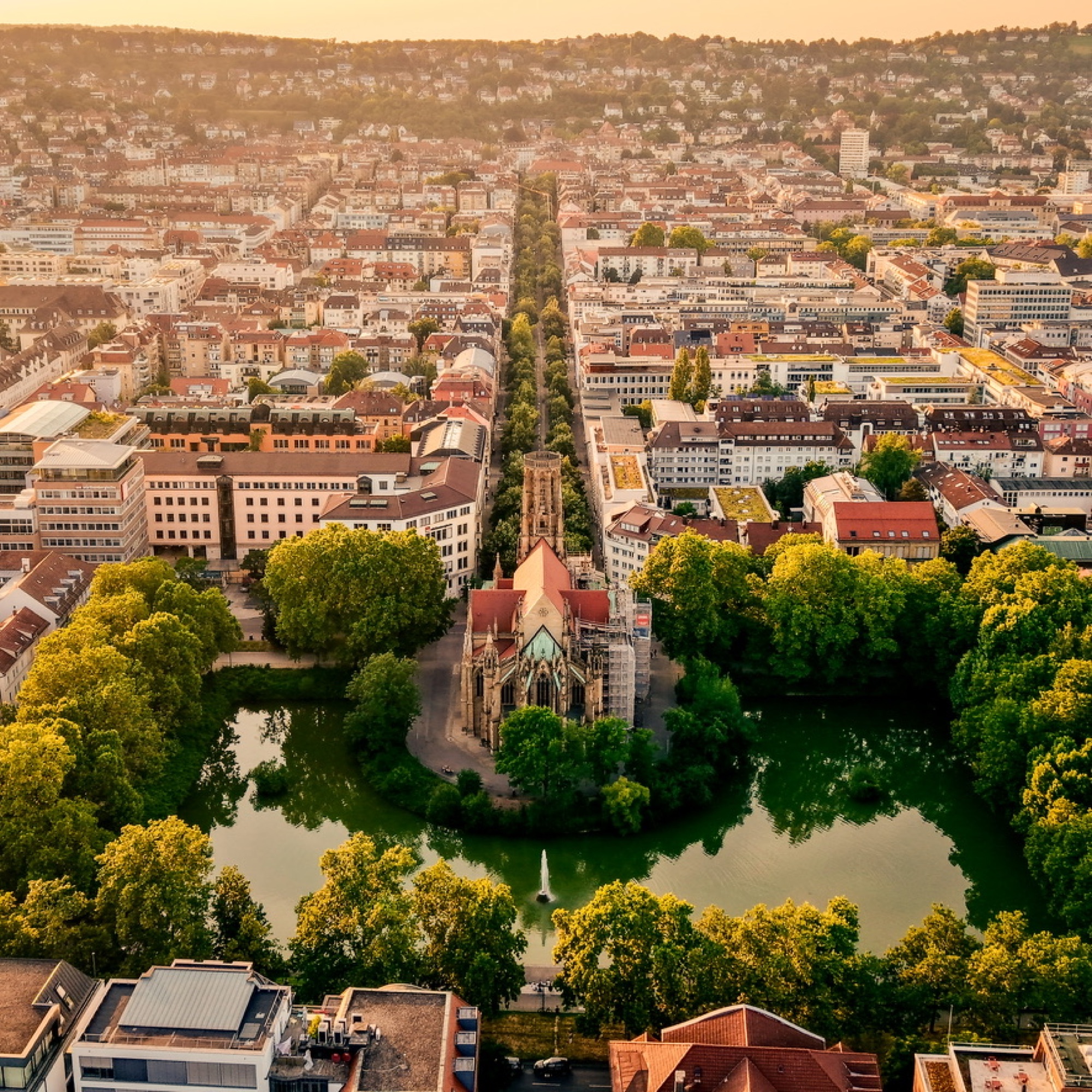 Gotische Kirche auf einer Insel im Parkteich, umgeben von Bäumen